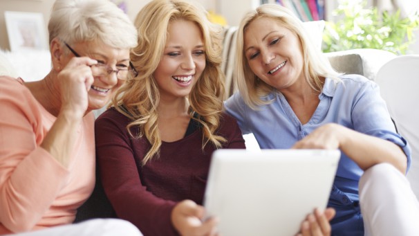 Loving family of women using digital tablet